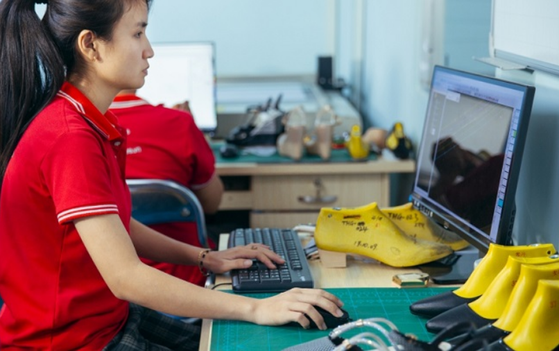 Công nhân tại xưởng đang sản xuất giày theo đơn đặt hàng